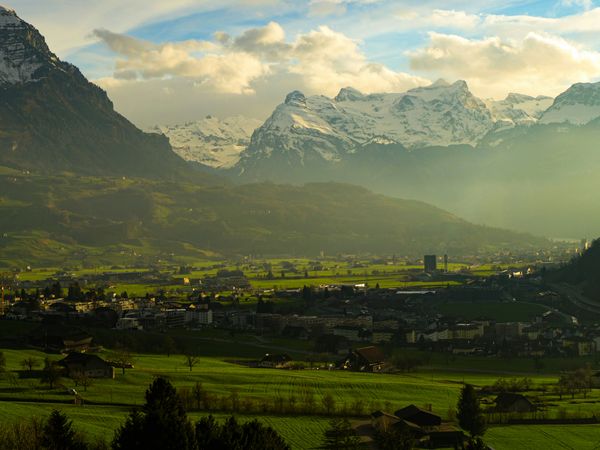 Image d'une petite ville entourée de collines et de montagnes